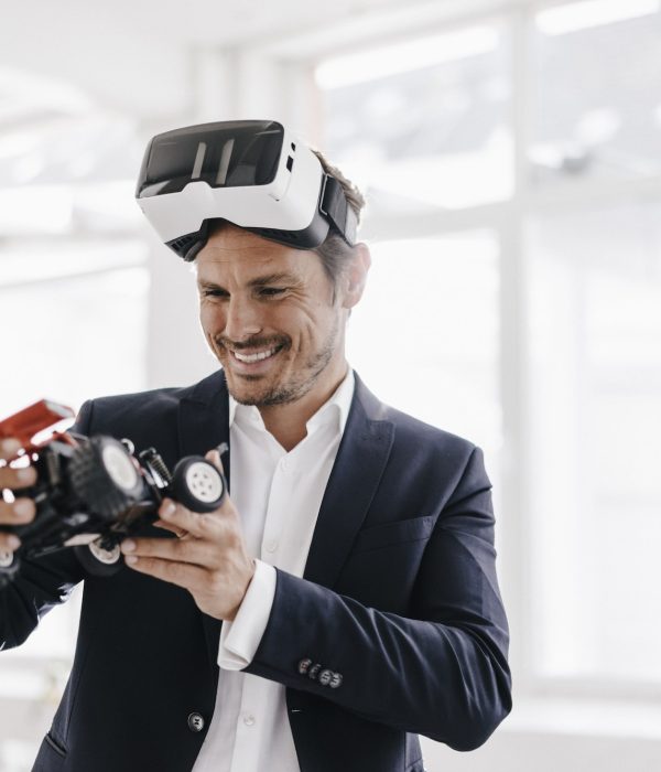 smiling-businessman-wearing-vr-glasses-looking-at-toy-racing-car.jpg